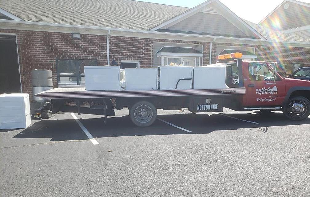 A tow truck is parked in front of a brick building