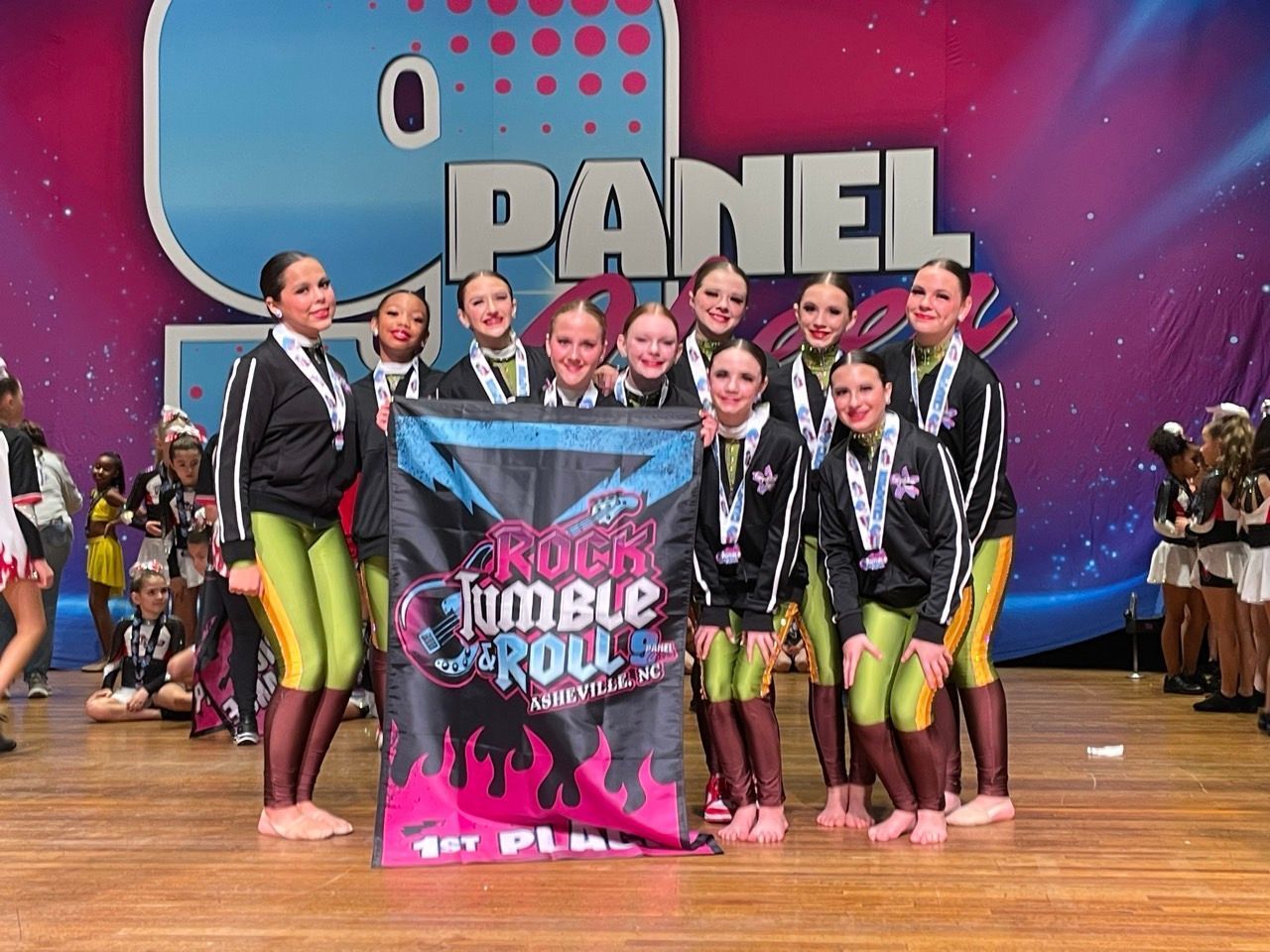 Group of dancers posing on stage with a