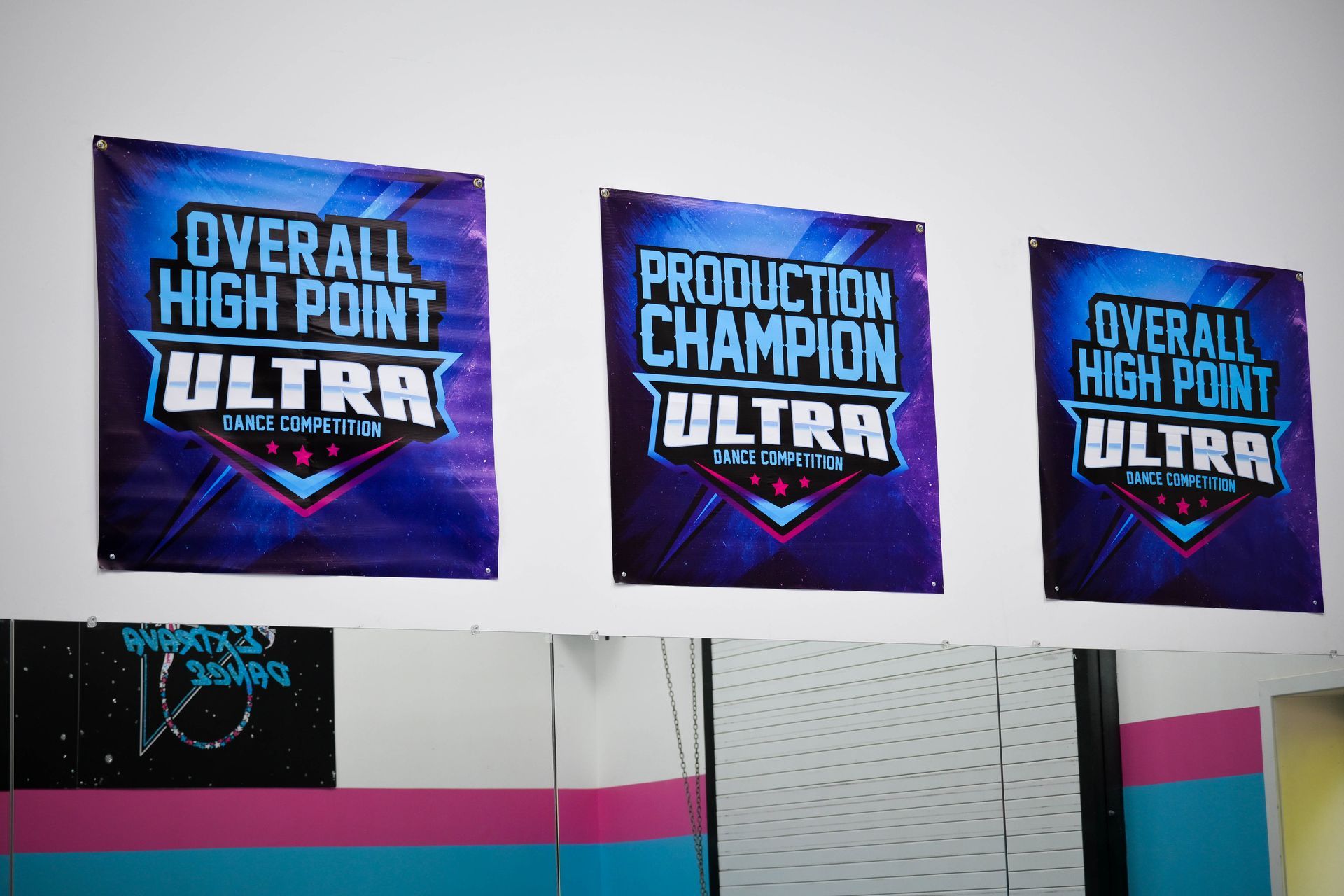 Three ULTRA cheer awards on a wall: Overall High Point, Production Champion, and Overall High Point
