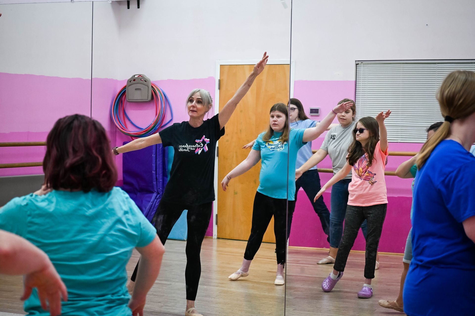 People doing a group fitness dance class in a studio with colorful walls