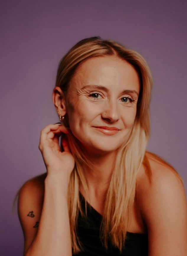 Portrait of a smiling blonde woman against a purple background