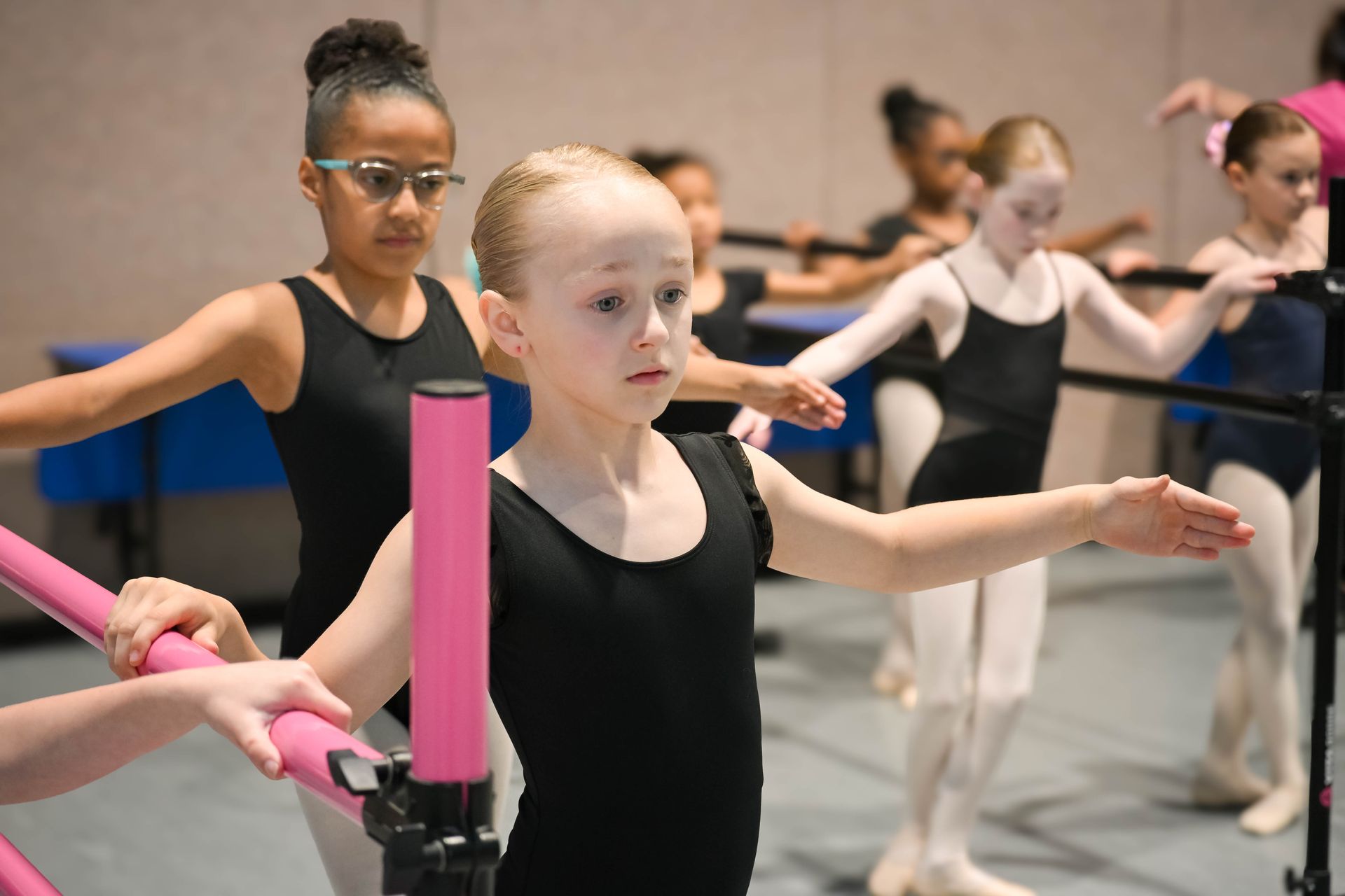 Ballet class with children practicing at the barre in a dance studio