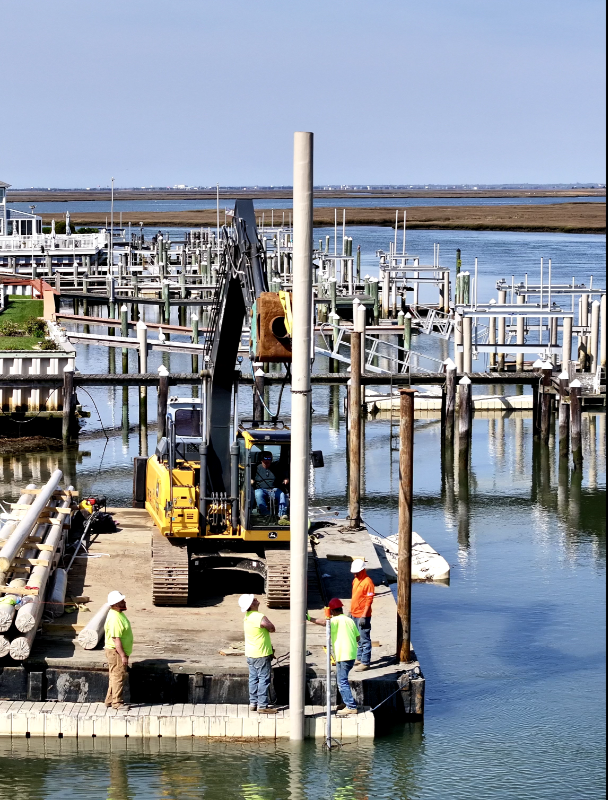 Construction workers are working on a dock near the water