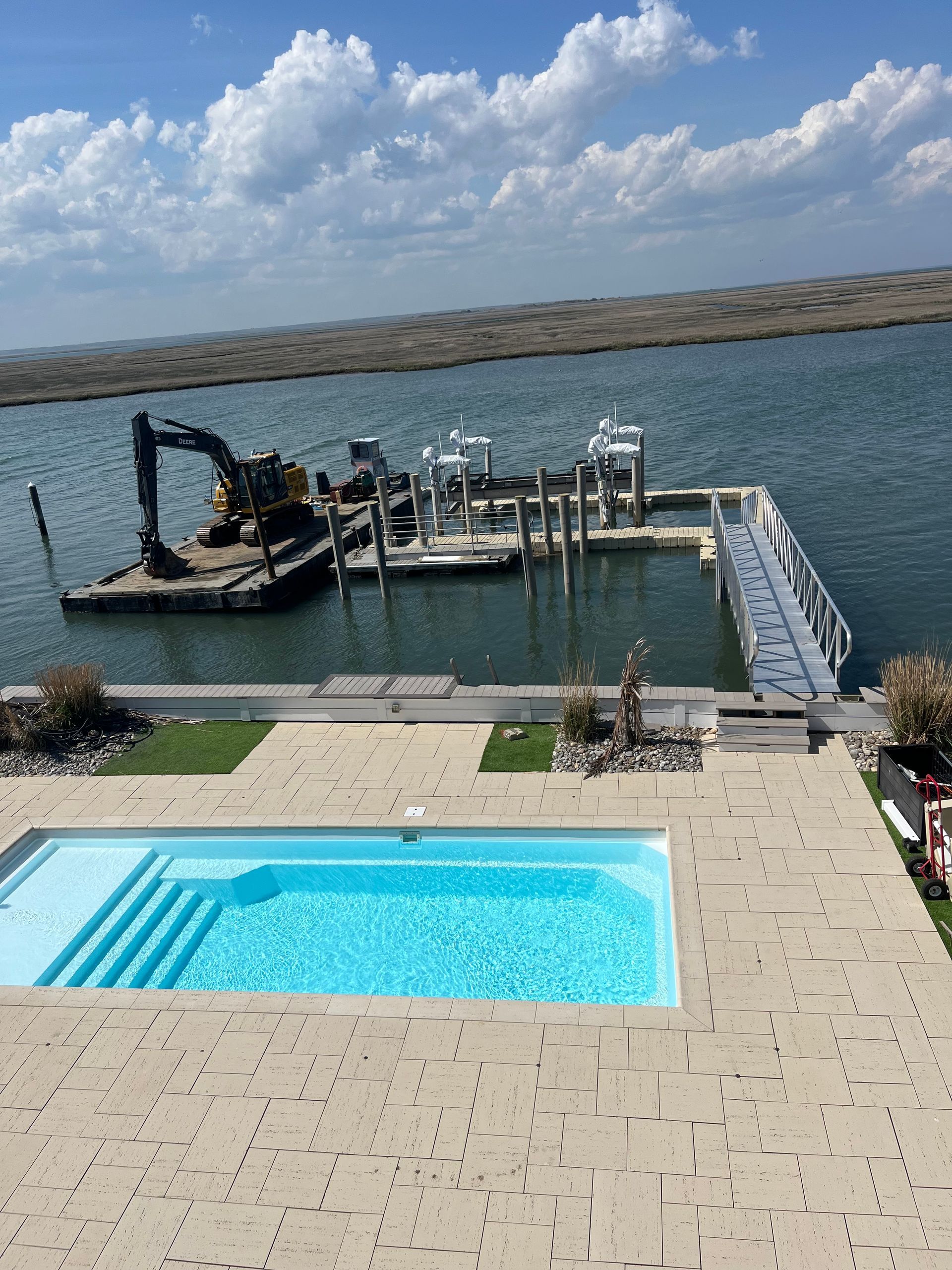 A large swimming pool with a dock in the background