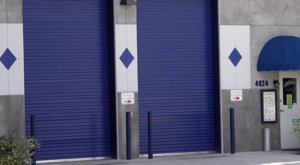 A building with blue garage doors and a blue awning