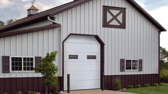 A white and brown barn with a white garage door.