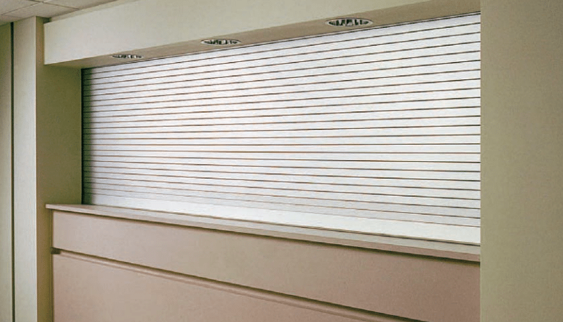 A white roller shutter is hanging on a wall in a room.