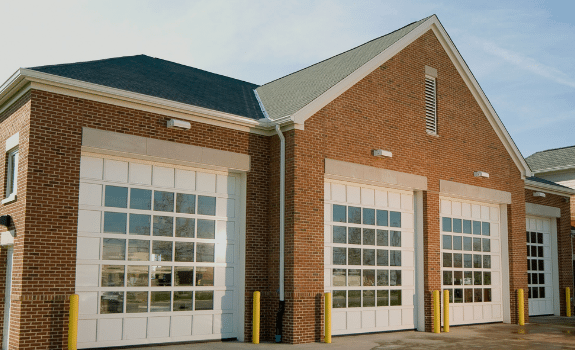 A red brick building with white garage doors