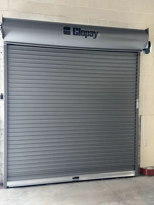 Gray rolling metal security door with