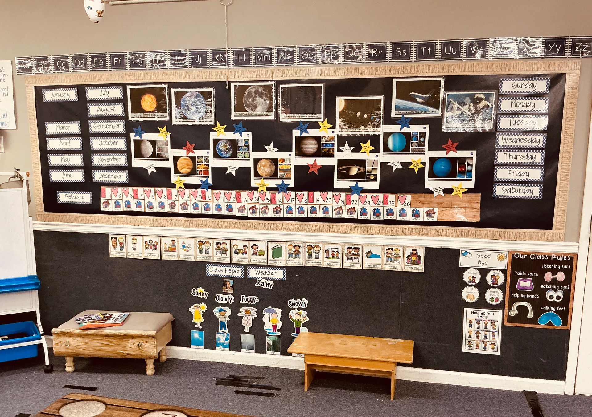 Classroom solar system display with planets, stars, and informational cards.