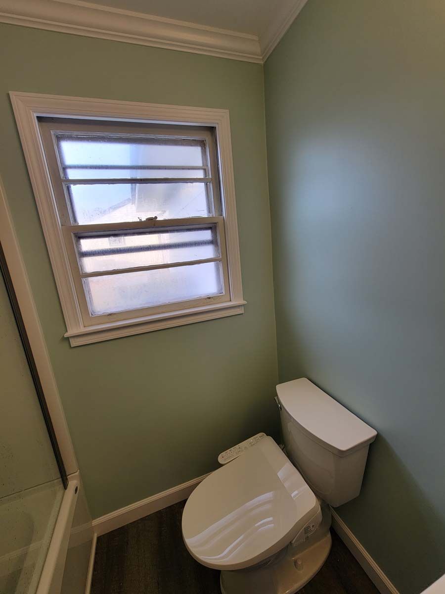 A bathroom with a toilet and a window