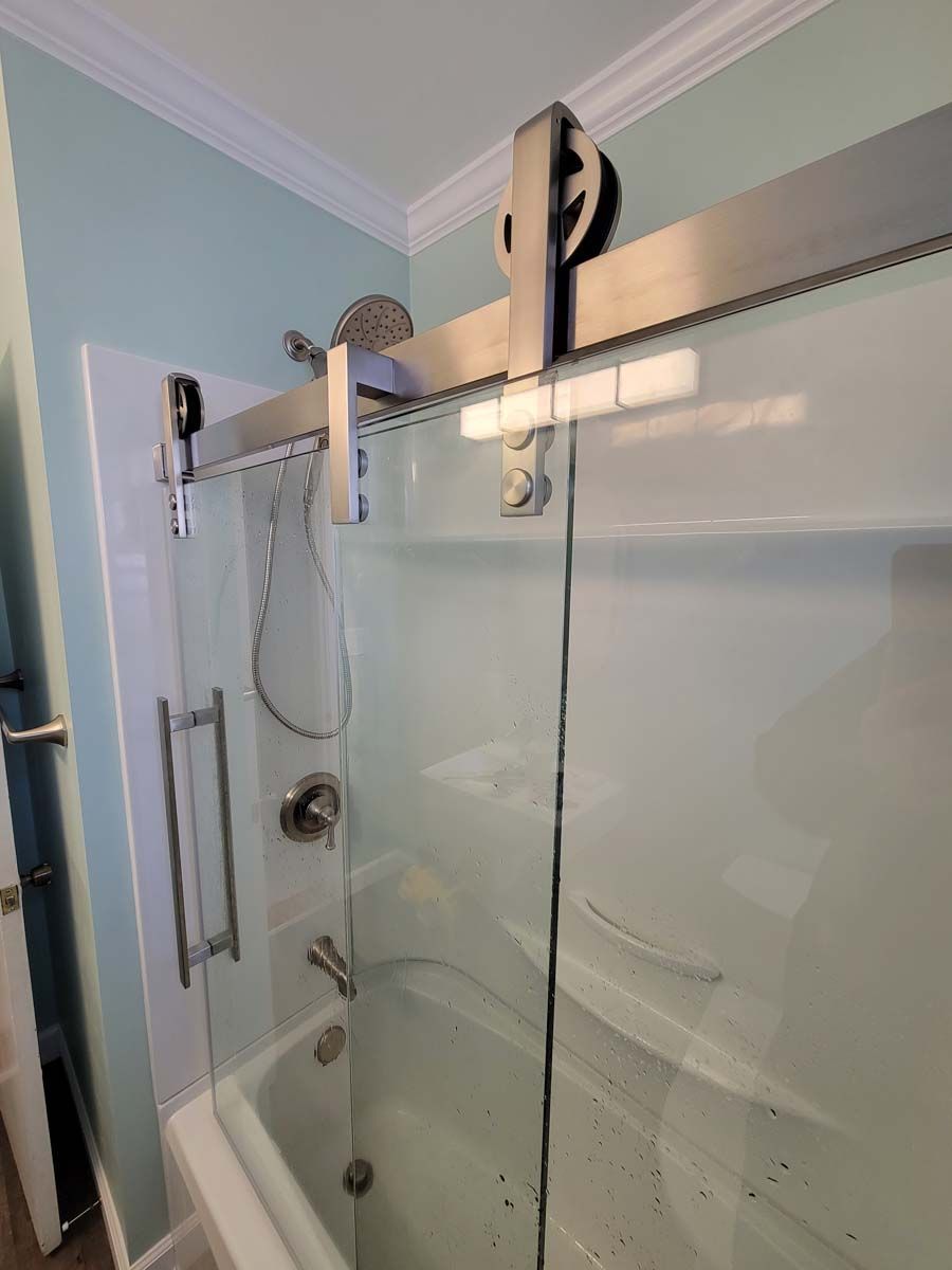 A bathroom with a sliding glass shower door and a bathtub.