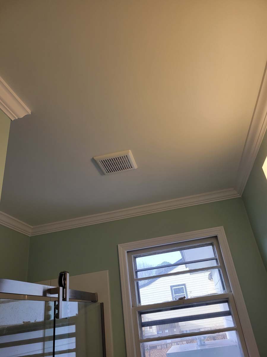 A bathroom with a window and a ceiling fan.