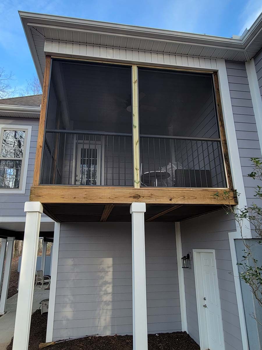 A screened in porch is being built on the side of a house.