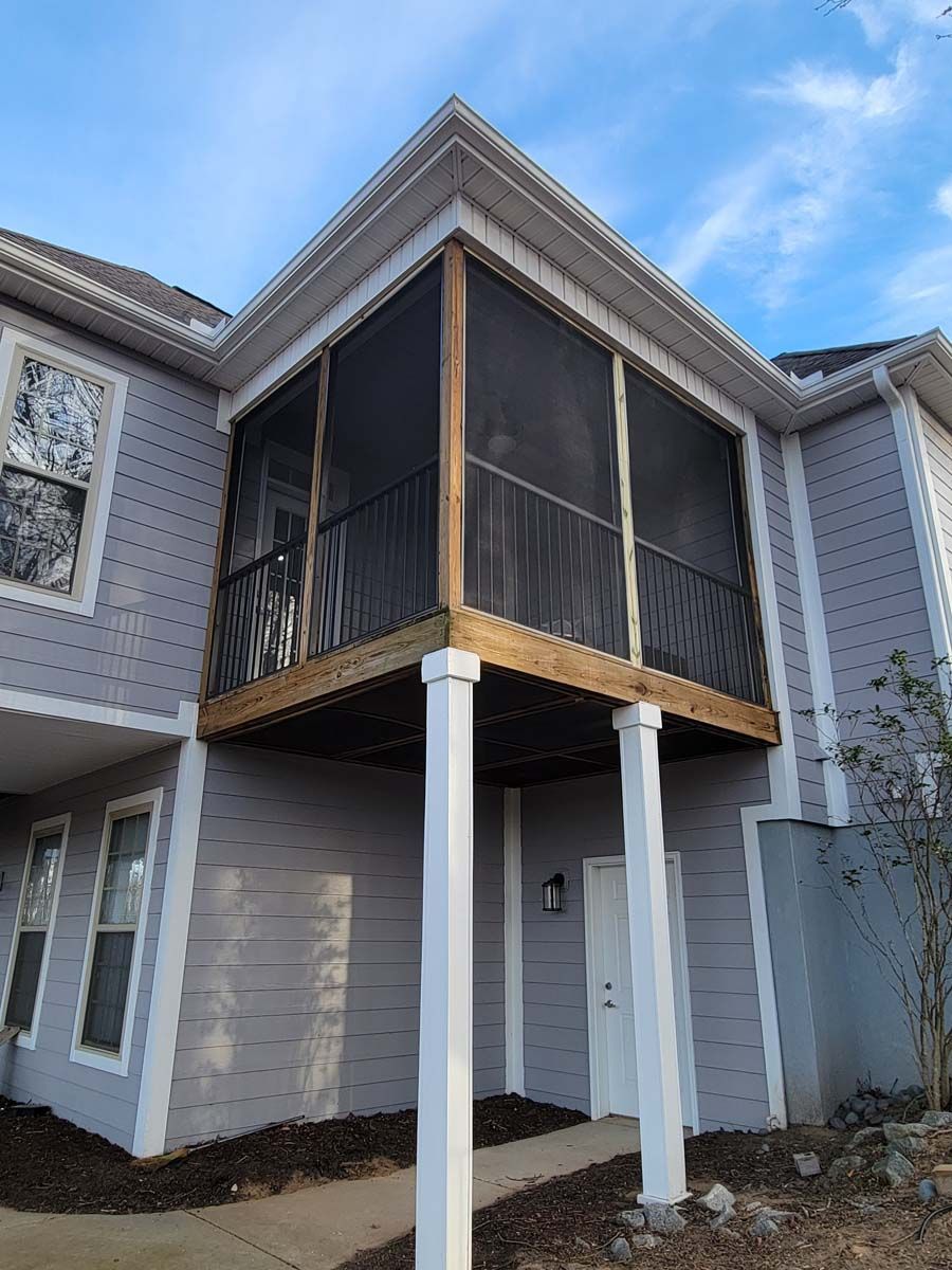 A house with a screened in porch on the side of it