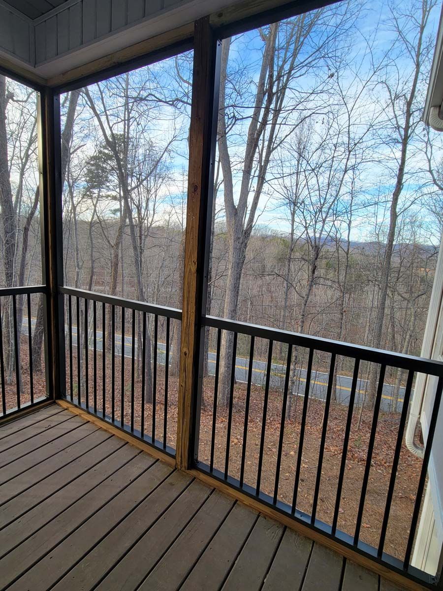 There is a screened in porch with a view of the woods.