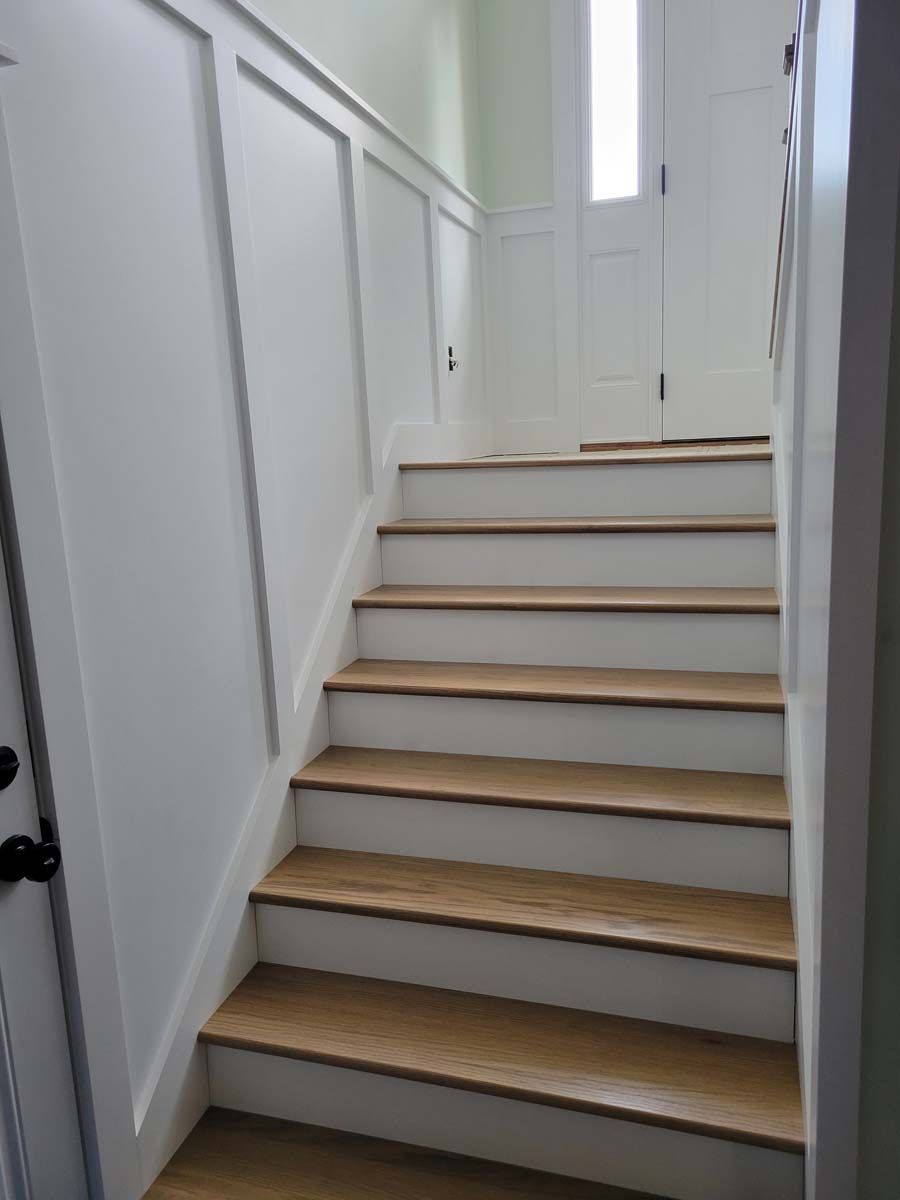 A set of stairs with wooden steps and white walls