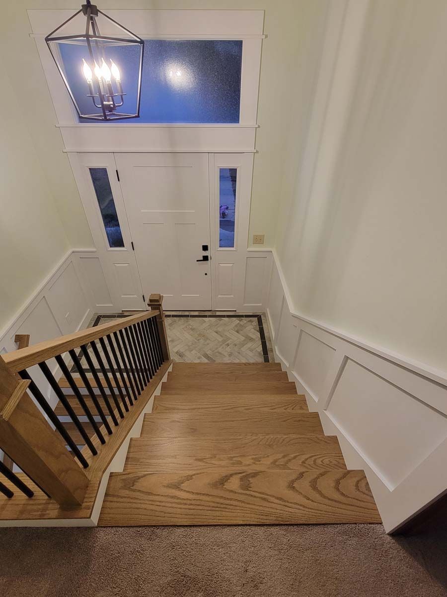A wooden staircase leading up to a white door in a house.