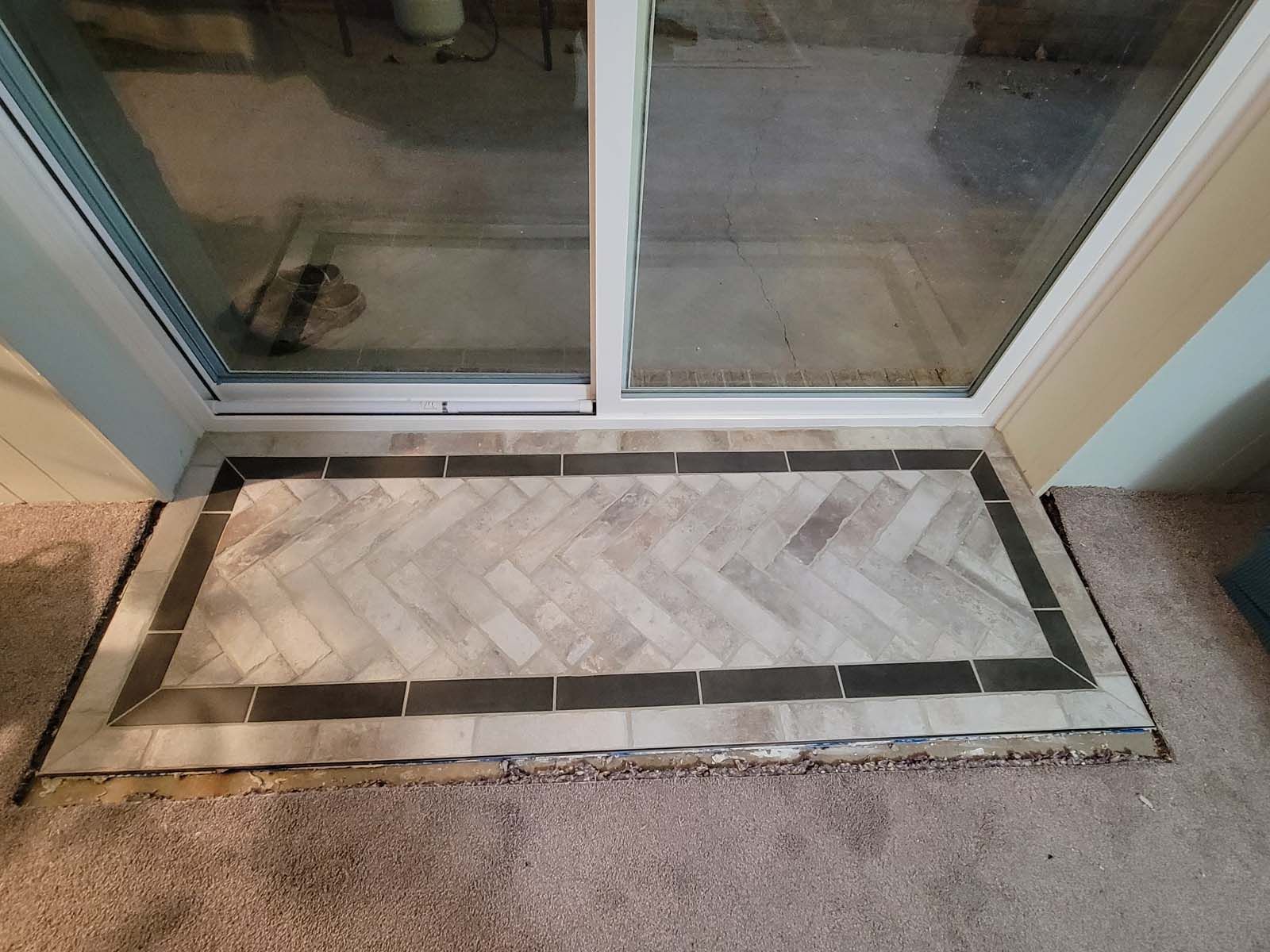 A sliding glass door with a rug on the floor in front of it