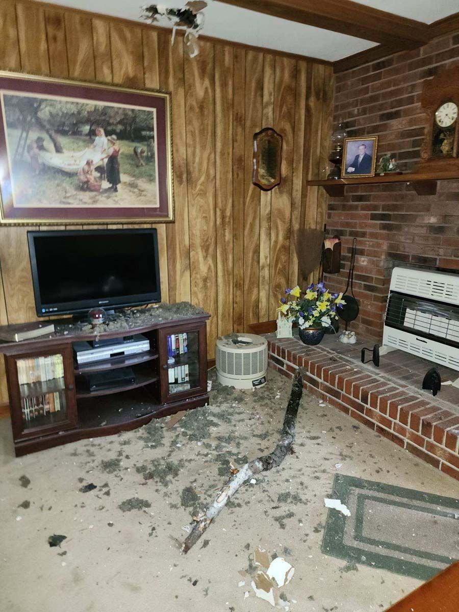 A living room with a brick fireplace and a flat screen tv