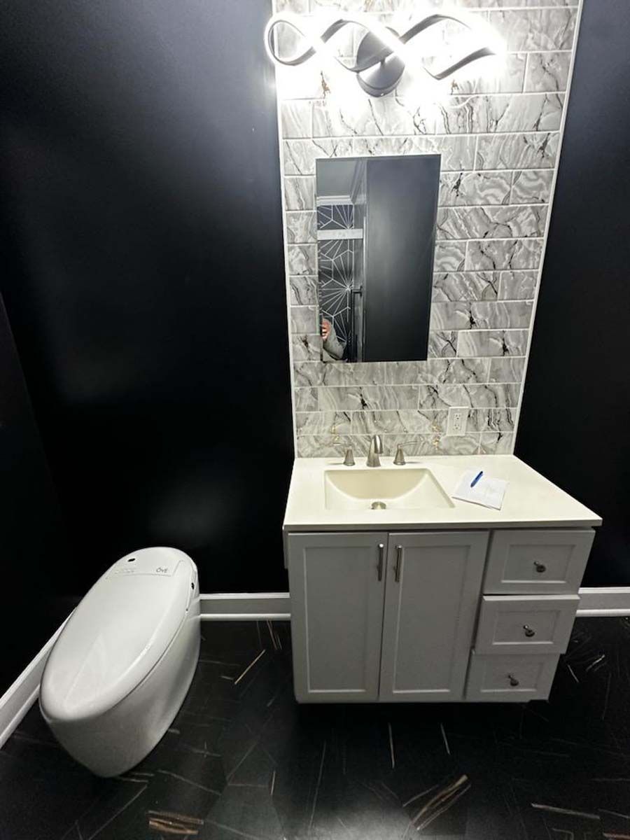 A bathroom with a sink , toilet and mirror.