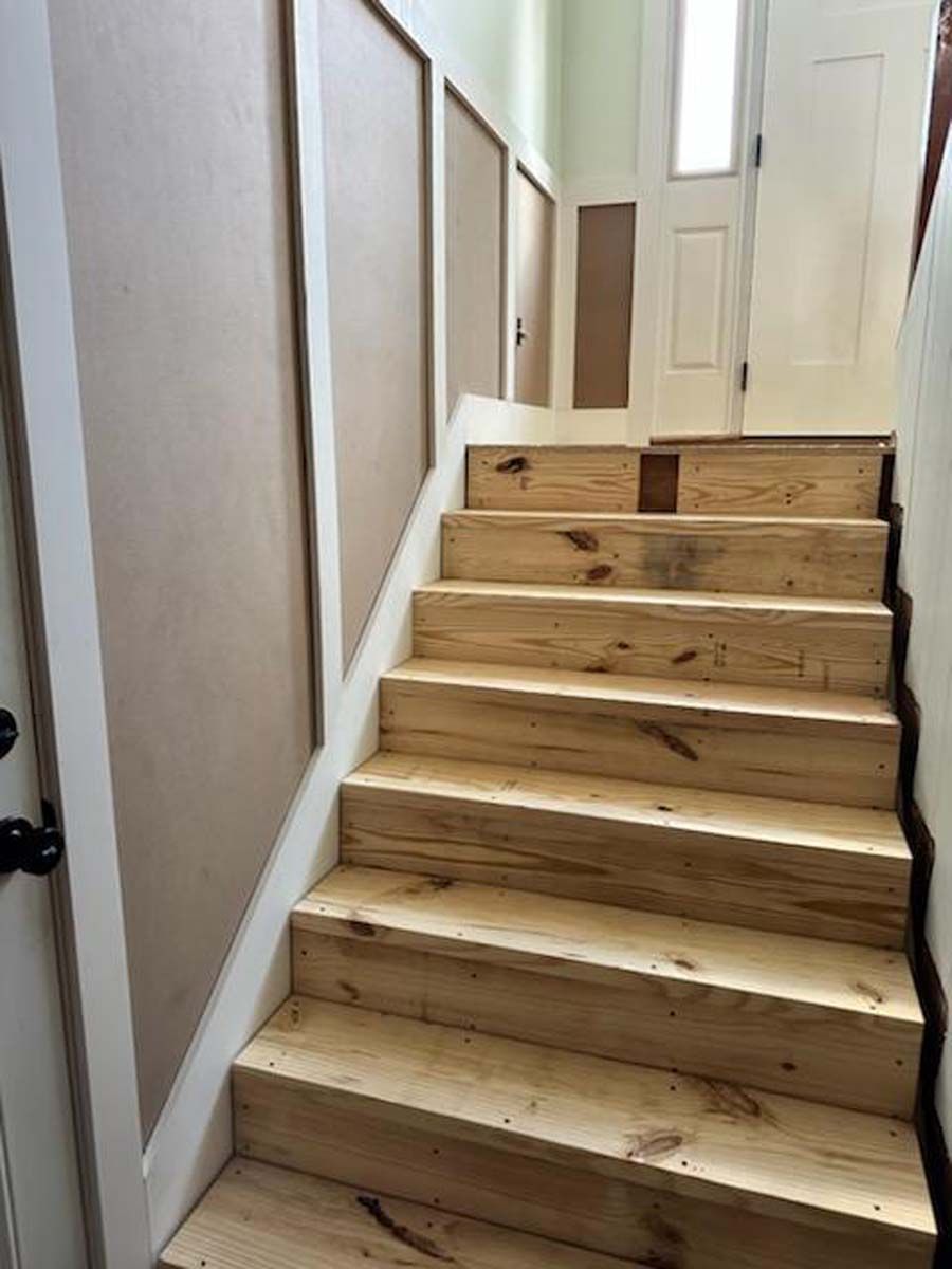 A set of wooden stairs leading up to the second floor of a house.