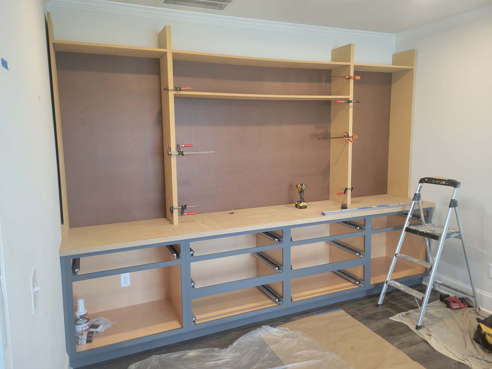 A room with a lot of shelves and a ladder.