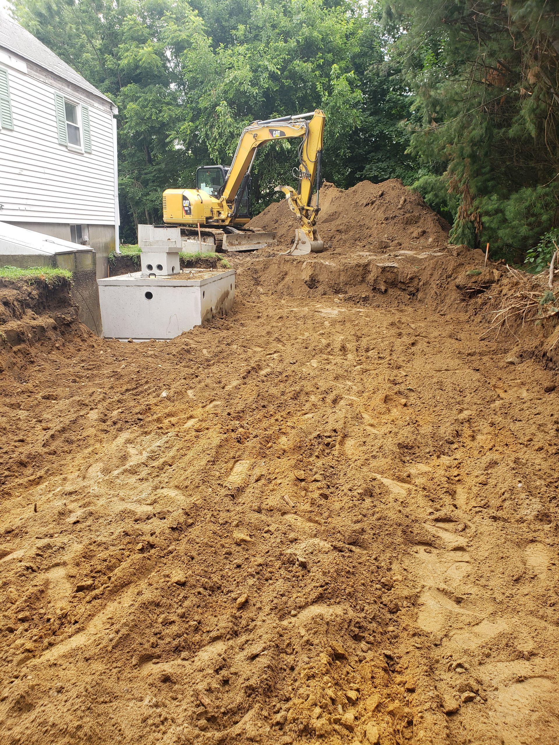a large pile of dirt is being excavated in front of a house