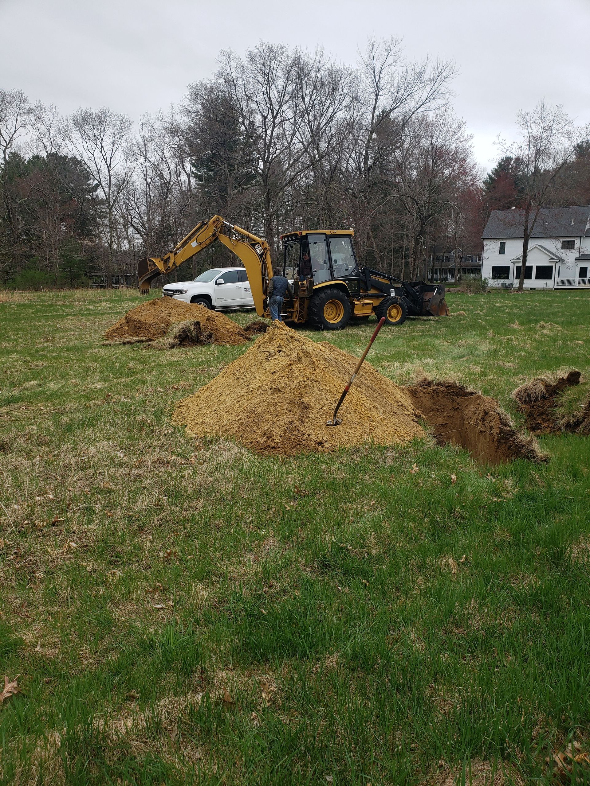 a bulldozer is digging a hole in a grassy field