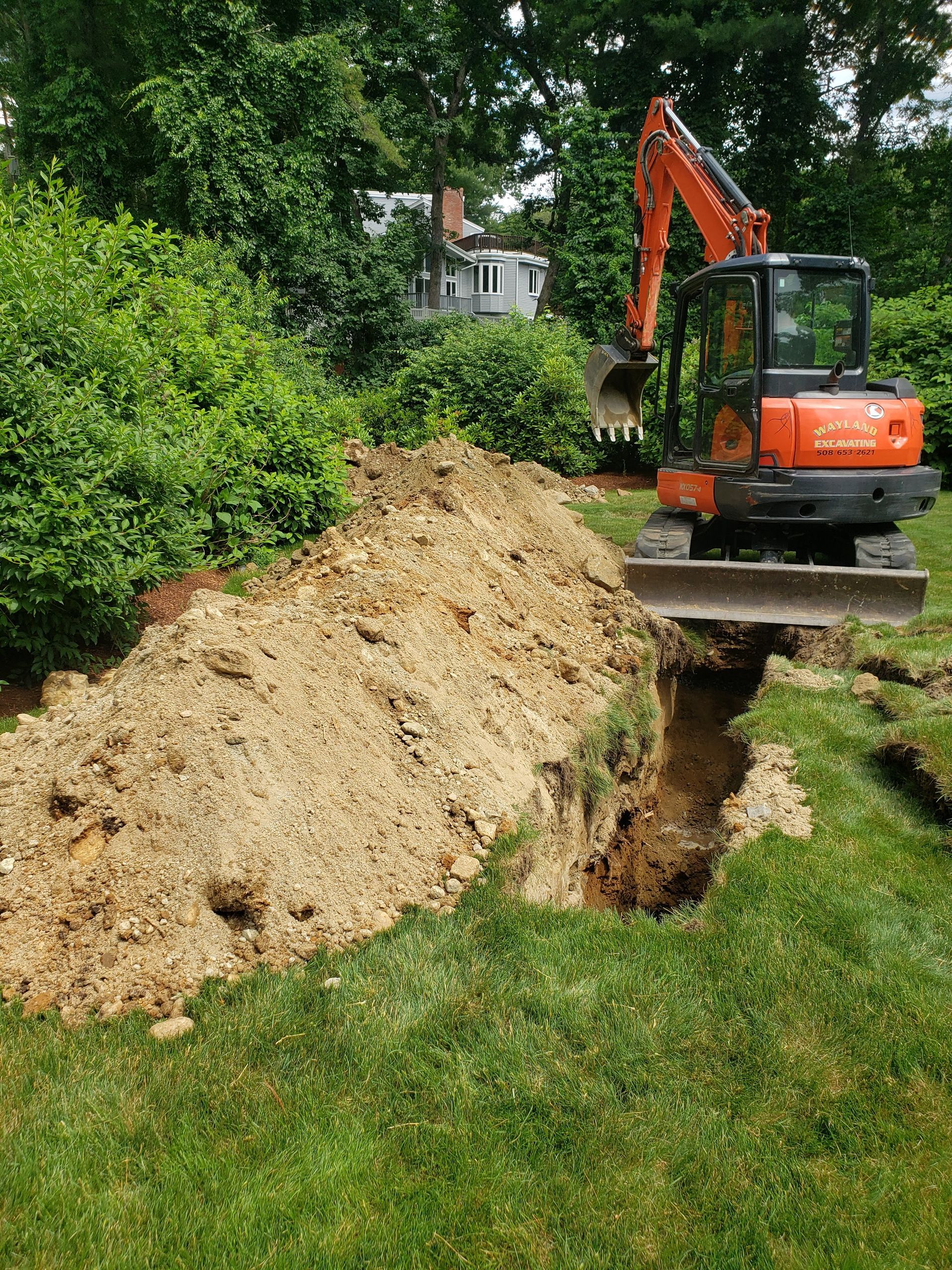 an excavator is digging a hole in the ground in a yard