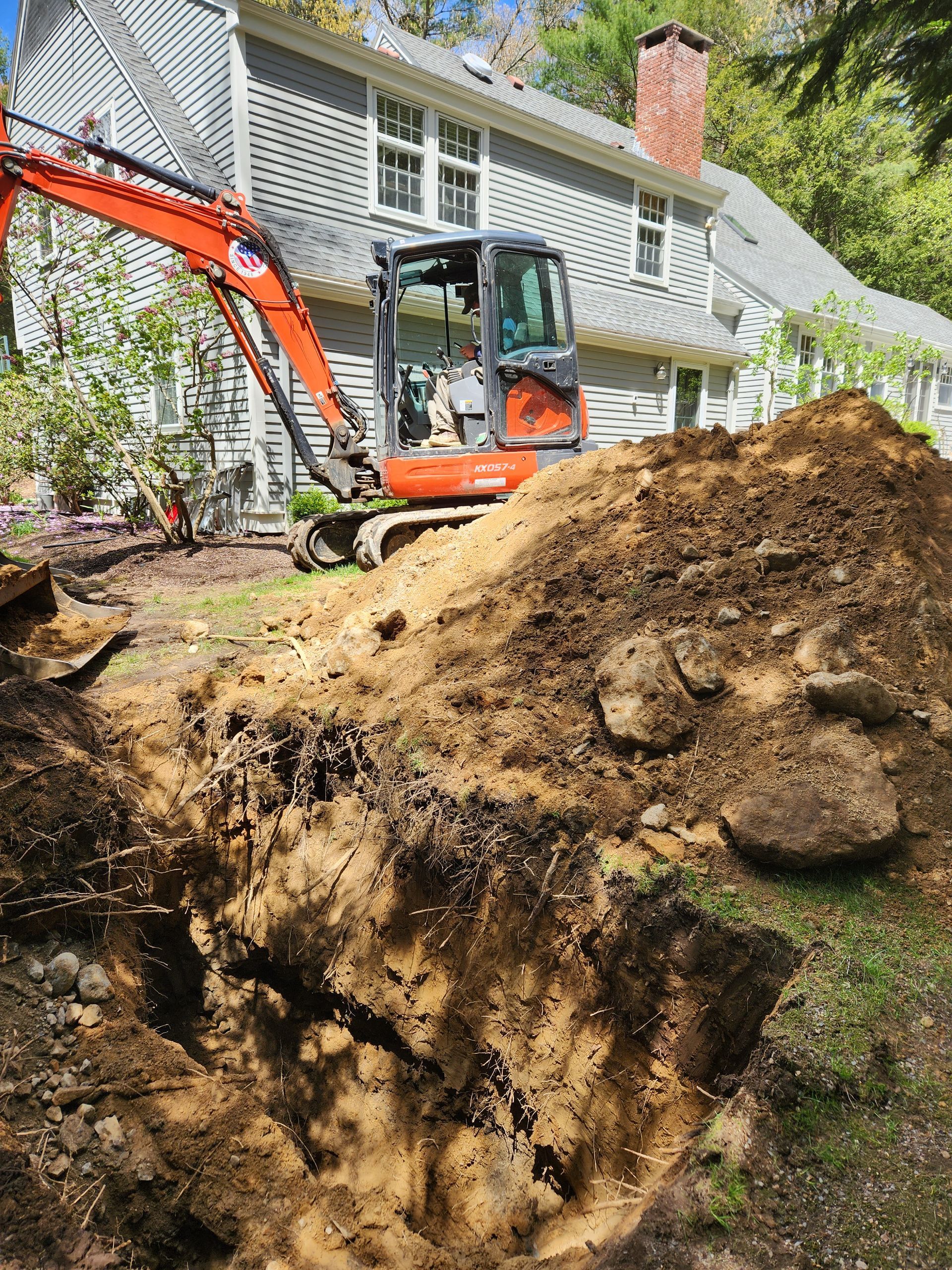 a large pile of dirt is being excavated in front of a house