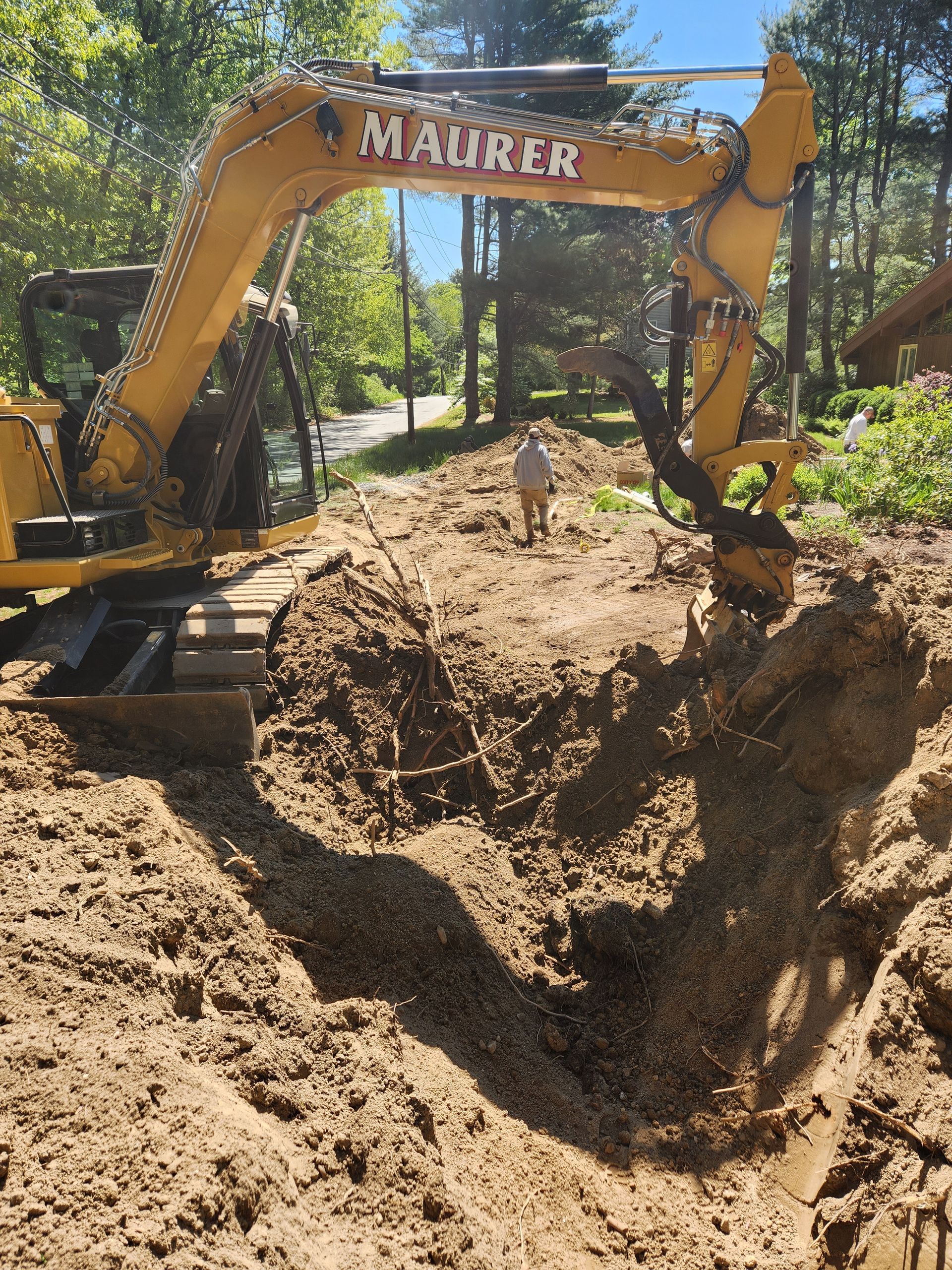 a yellow excavator is digging a hole in the dirt