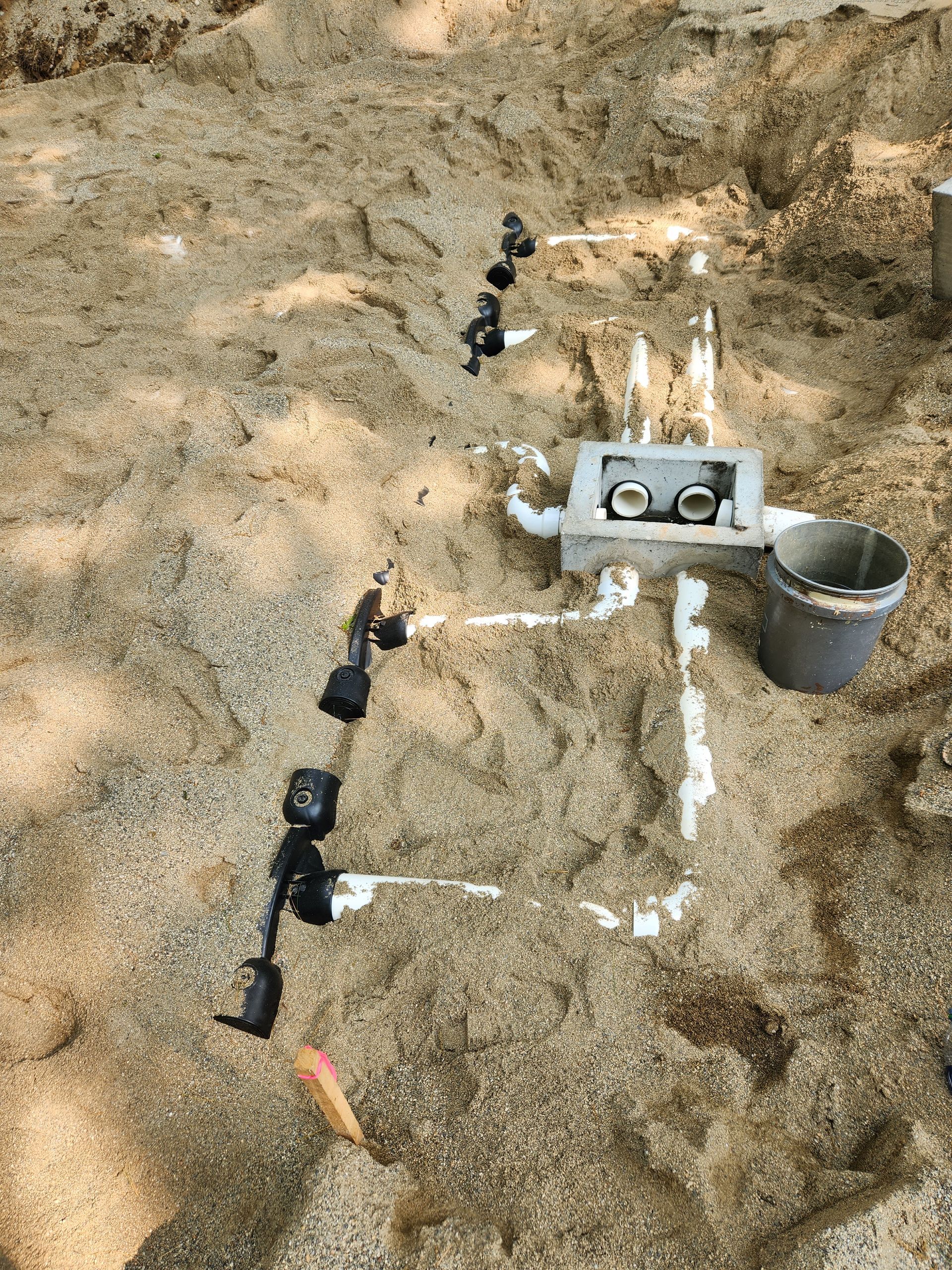 a bucket of cement is sitting on top of a pile of dirt