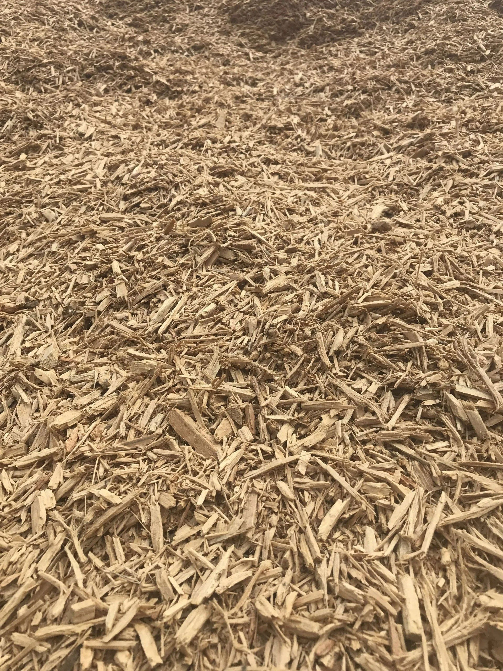 Brown wood chips or mulch covering the ground in a close-up view