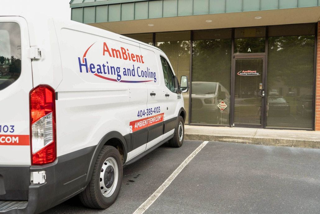 White service van parked outside a storefront, with “AmBient Heating and Cooling” on the side.