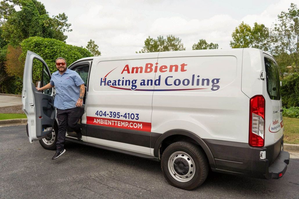 AmBient Heating and Cooling service van with open door and a person standing beside it.