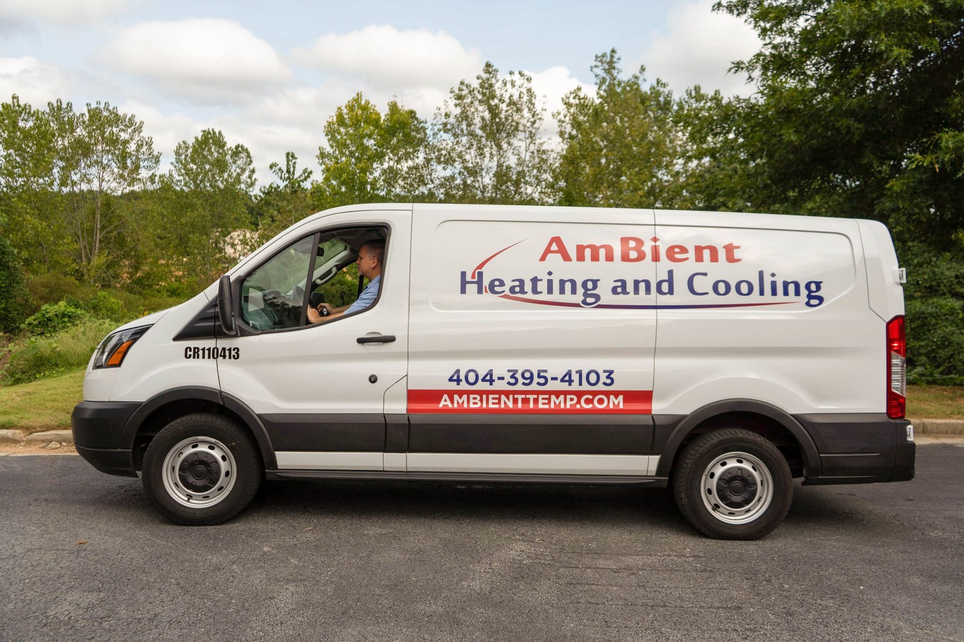 White HVAC service van with “AmBient Heating and Cooling” branding parked on a road
