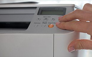 Hand on the buttons of a copier