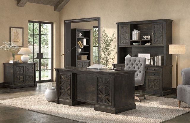 Office with a dark wood desk, hutch, bookcase, and cabinet, a tufted chair, and a rug.