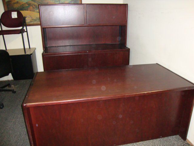 Dark wood office desk with hutch. A chair and a black cabinet are visible nearby.
