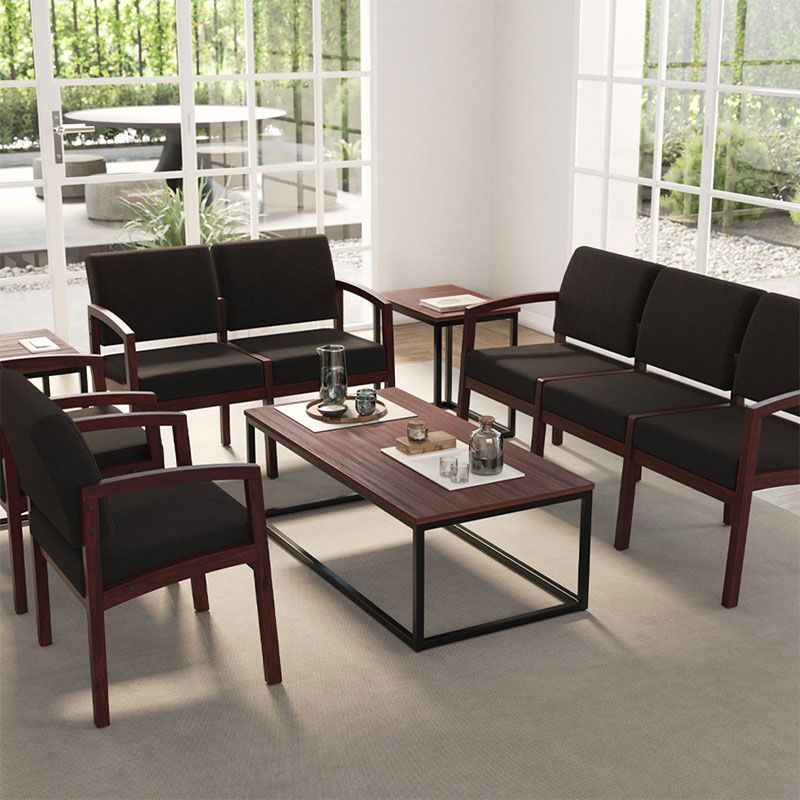 Living room furniture: black couches, chairs, and tables with brown frames and a black framed coffee table.
