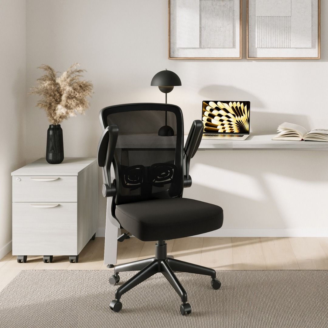 Black office chair in a modern office setup with a desk and filing cabinet.