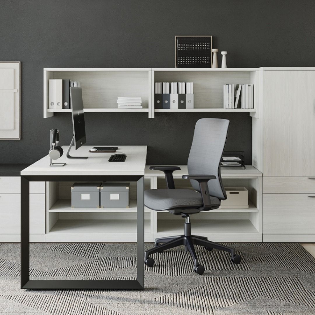 Modern office setup with white desk, grey chair, and built-in white shelving against a dark gray wall.
