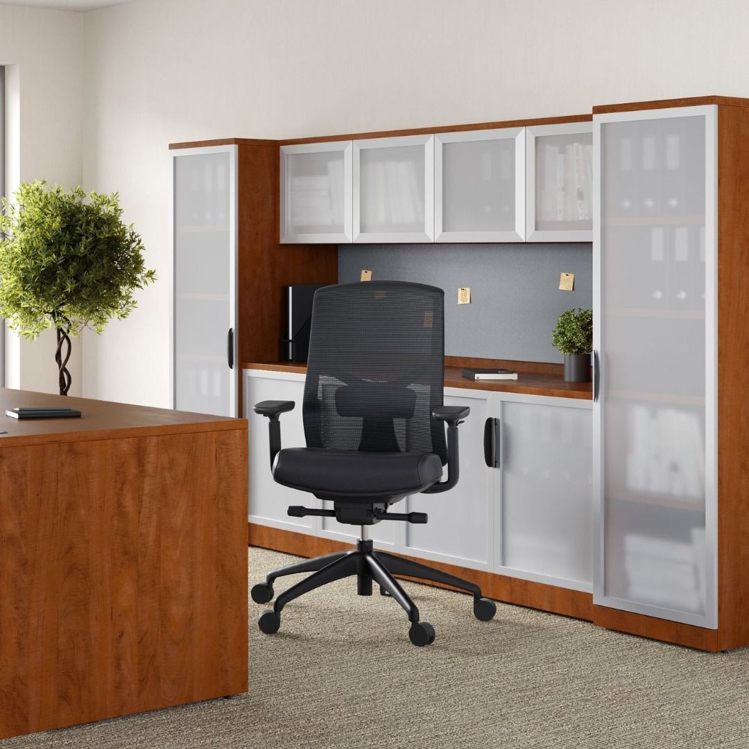 Office with brown and white cabinets, black desk chair, and small plant.