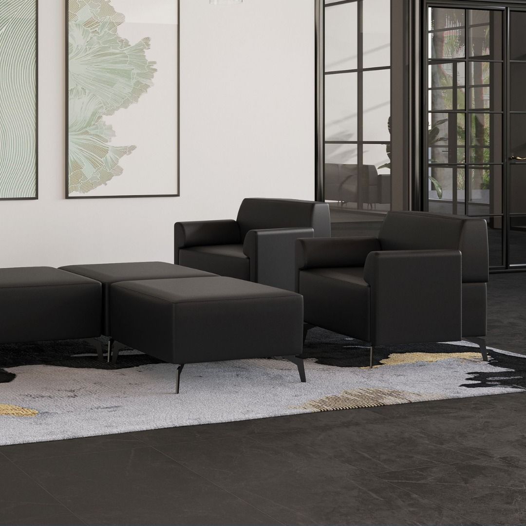 Black leather seating with ottoman set on a patterned rug in a modern room.