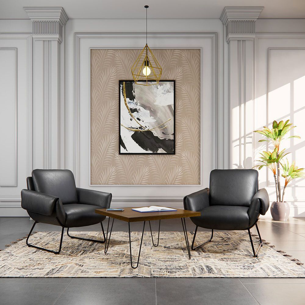 Two black armchairs and a coffee table in a living room setting, with artwork and a hanging light.