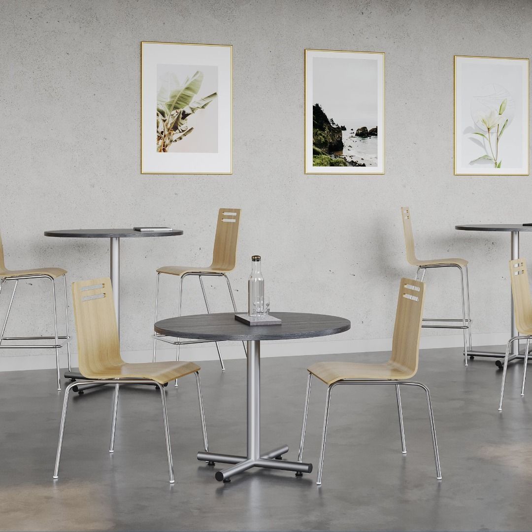 Cafe with tables, chairs, water bottle. Artwork hangs on the wall.