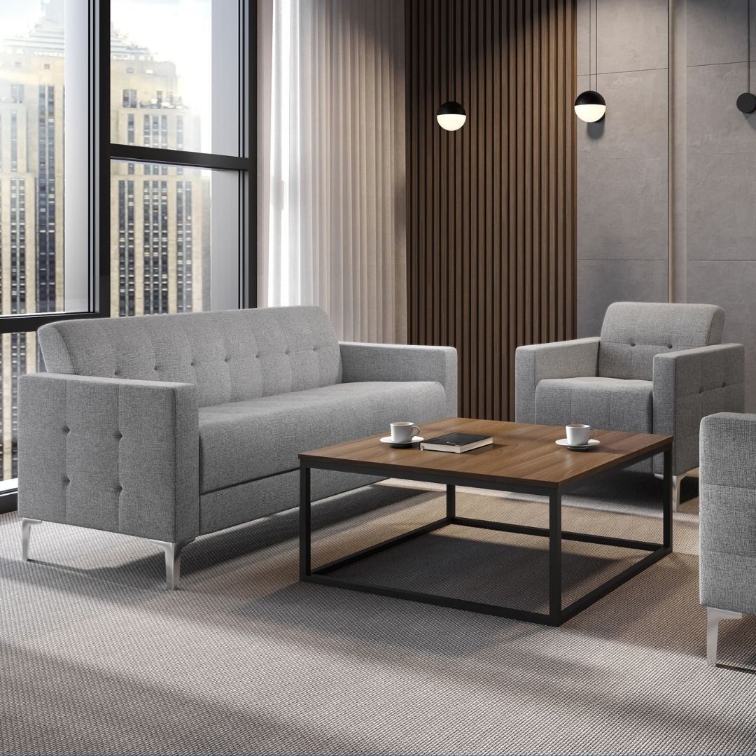 Gray sofa and armchairs in a modern office with coffee table and city view.