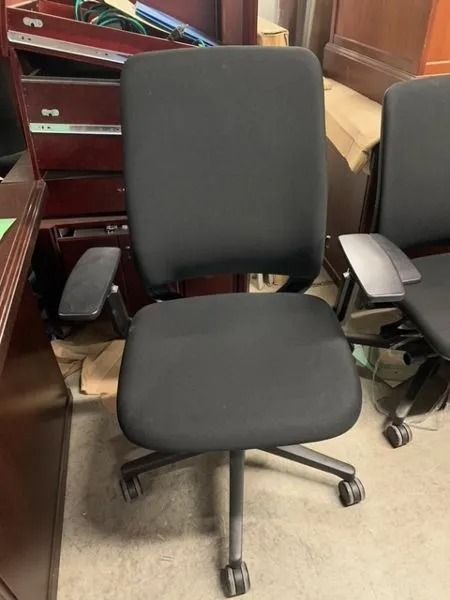 Black office chair with adjustable arms on a wheeled base.
