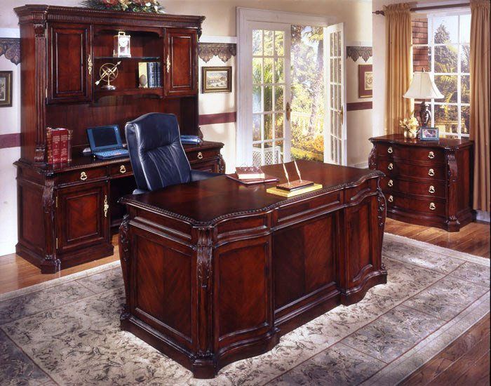 Executive office set with dark wood desk, hutch, and matching cabinet on a patterned rug.